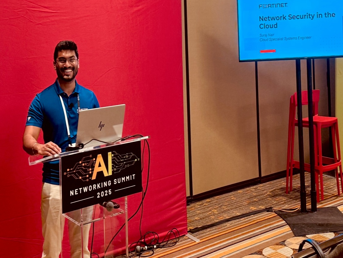 Suraj at the ONUG AI Networking Summit lectern beside a Network Security in the Cloud slide